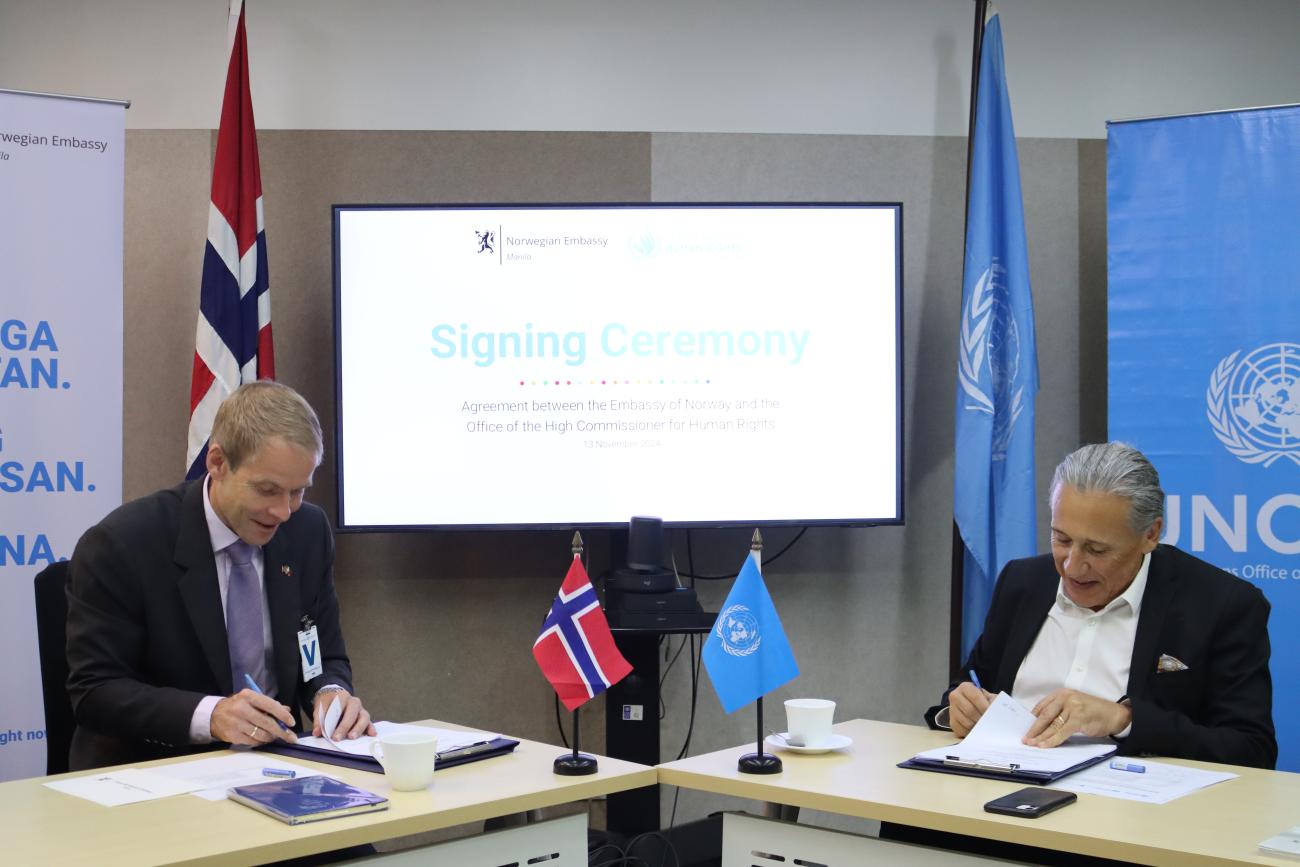 The Norwegian Ambassador to the Philippines and UN Philippines Resident Coordinator sit adjacent to each other, signing documents.