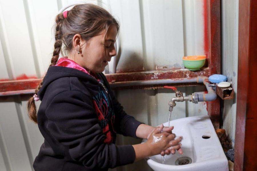 Syrian girl washes her hands